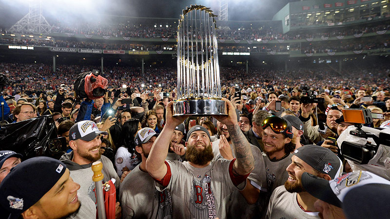 Boston Red Sox players celebrating with the 2013 World Series trophy at Fenway Park.